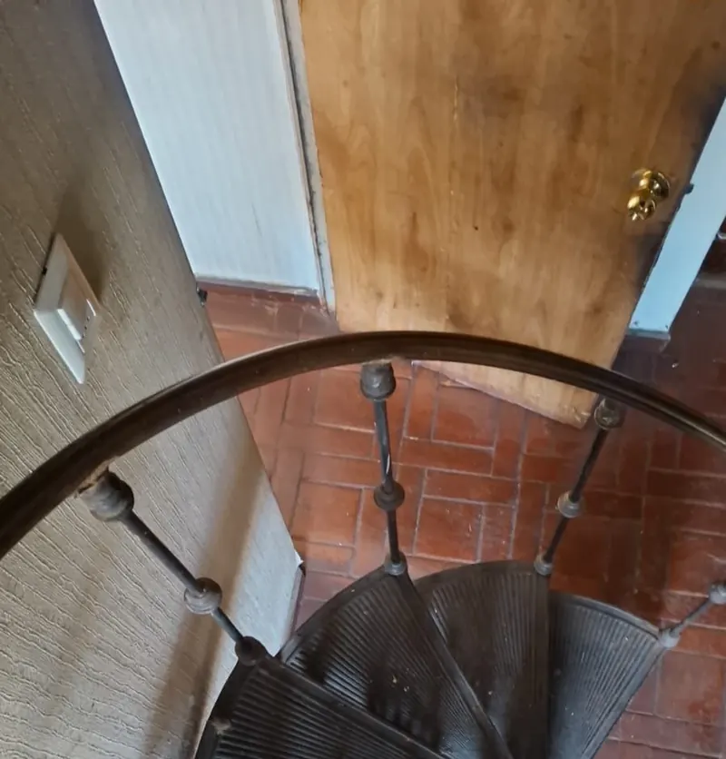 Escalera de caracol de fierro fundido, con baranda ornamental, otra vista