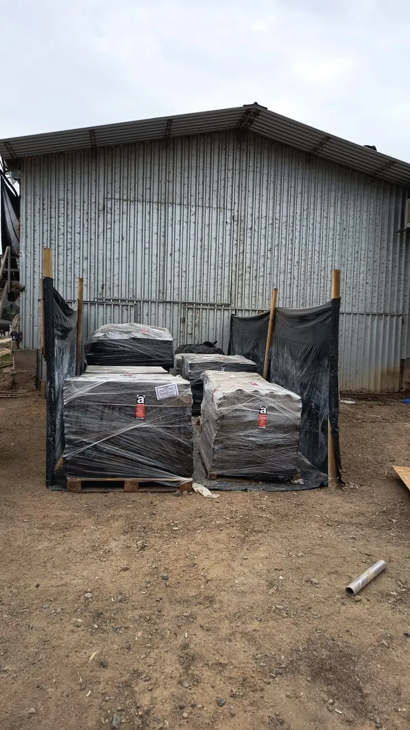 Material con asbesto embalado y encapsulado en pallets dentro de un acopio cercado