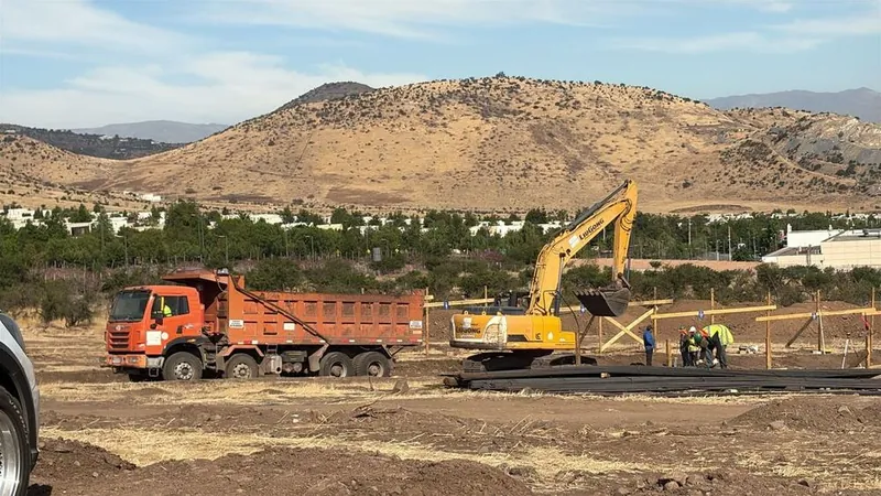Camión tolva y excavadora retirando escombros de un terreno