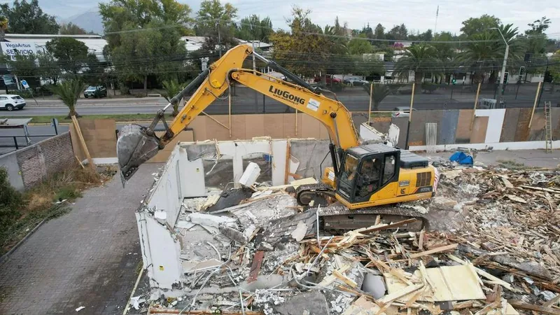 Excavadora demoliendo una vivienda de un piso en Santiago