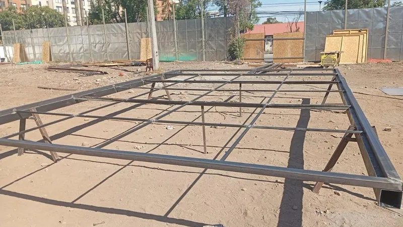 Estructura metálica desarmada en el suelo de la obra
