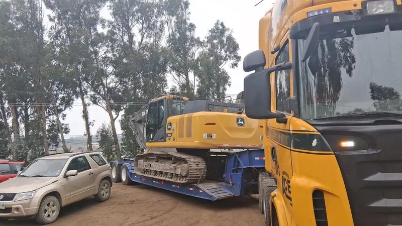 Excavadora llegando a la obra sobre un camión cama baja