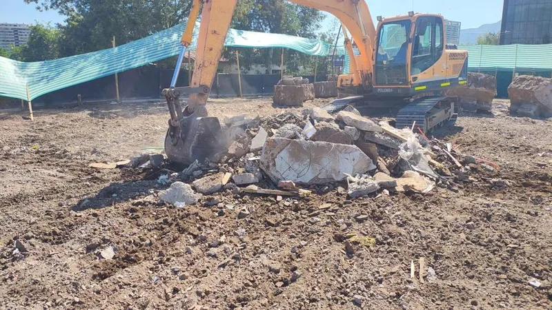 Excavadora moviendo escombros de hormigón en un terreno en demolición