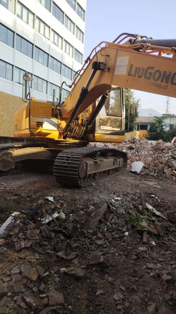 Excavadora LiuGong en faena de demolición junto a un edificio